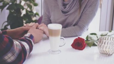 Couple of young people are in the cafe. The guy and the girl went to have a latte. Close up. Copy space. Action. Animation. 4K.