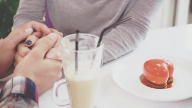 Couple of young people are in the cafe. The guy and the girl went to have a latte. Close up. Copy space. Action. Animation. 4K.