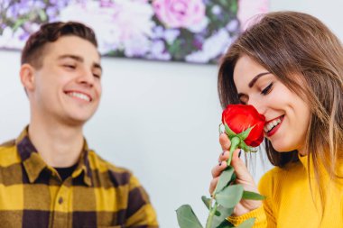 Şehvetli kız, erkek arkadaşının ona verdiği gülün kokusunu alıyor. Ona sevgiyle bakıyor, hediyesini beğenmesinden memnun..