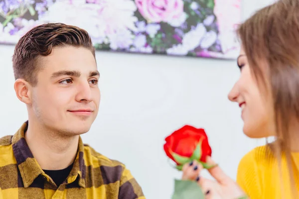 Concept d'appréciation. Belle femme souriante avec rose rouge à la main est vraiment reconnaissante à son homme bien-aimé pour un tel cadeau. — Photo