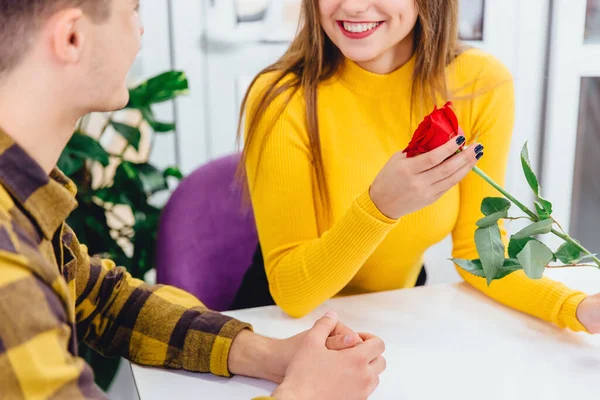 Setter pris på konseptet. Vakre, smilende kvinne med rød rose i hånden er virkelig takknemlig til sin elskede mann for en slik presang.. – stockfoto