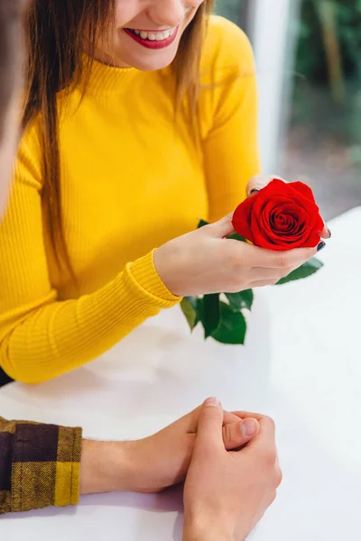 Tiro cortado de jovens, encontrando-se no café em ocasião especial, menino deu uma rosa vermelha para sua namorada adorável . — Fotografia de Stock