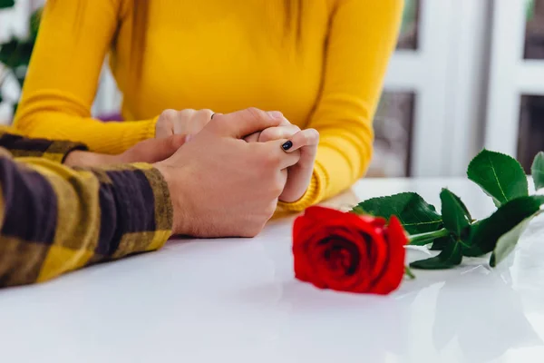 Καλλιεργημένη φωτογραφία ερωτευμένου ζευγαριού να κρατιέται χέρι-χέρι σε λευκό τραπέζι. Πνεύμα ισχυρών αληθινών συναισθημάτων στον αέρα. — Φωτογραφία Αρχείου