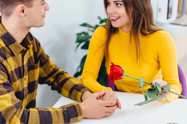 A fiatalember virágot ad a barátnőjének, fogja a kezét, és határozottan megkéri a kezét.. — Stock Fotó