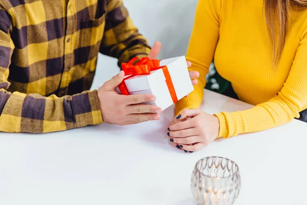 Beskuren bild av mannen ger sin flicka en present med rött band vid något tillfälle. — Stockfoto