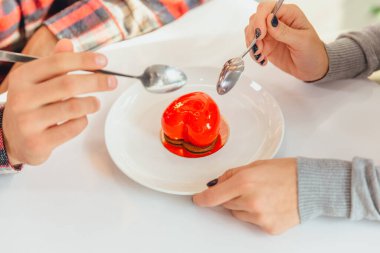 Kalp şeklinde mus tatlısı ve insanların elleri, kaşıklar, bu şekeri tatmak, Sevgililer Günü 'nü kutlamak..