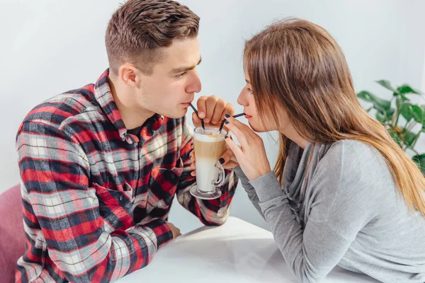 Mujer y hombre beben café cada mañana en el mismo lugar que la tradición. Están bebiendo latte con pajitas del mismo vaso. . —  Fotos de Stock