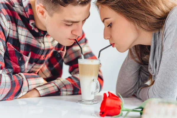 Recortado disparo de pareja romántica disfrutando de la compañía de los demás, beber café del mismo vaso con pajitas, sentado en la cafetería . —  Fotos de Stock