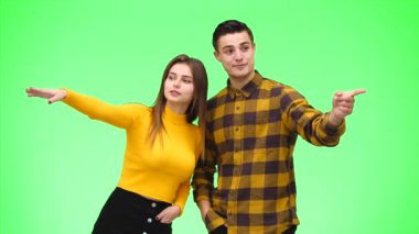 Young happy couple is showing something together. Close up. Copy space. 4K.