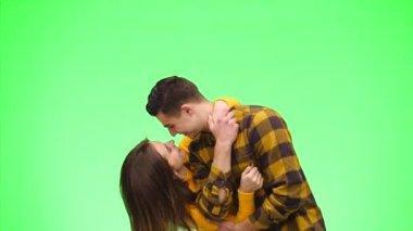 Şefkatli bir çift yeşil bir arka planda samimi bir şekilde gülümsüyor. Kapatın. Uzayı kopyala 4k.