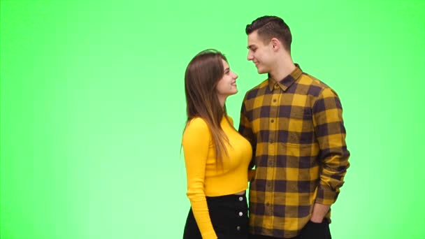Tenera coppia amorevole sorride sinceramente e coccolarsi su uno sfondo verde. Ricevuto. 4K . — Video Stock