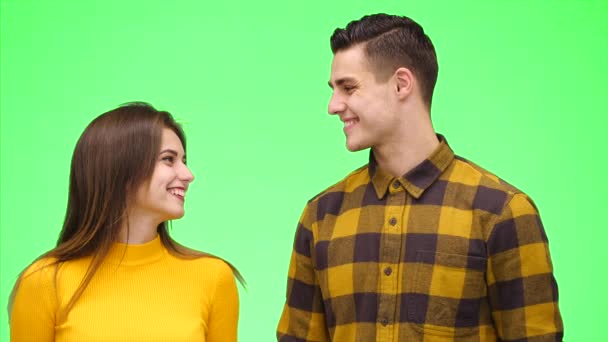 Un couple tendre et aimant sourit sincèrement et se blottit sur un fond vert. Ferme là. Espace de copie. 4K . — Video