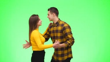 Yeşil arka planda dans eden genç romantik çift. Kapatın. Uzayı kopyala 4k.
