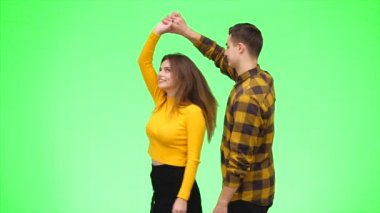Yeşil arka planda dans eden genç romantik çift. Kapatın. Uzayı kopyala 4k.