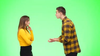 Genç bir kadın genç bir adamla tartışıyor, yeşil bir geçmişi var, izole edilmiş. Uzayı kopyala 4k.