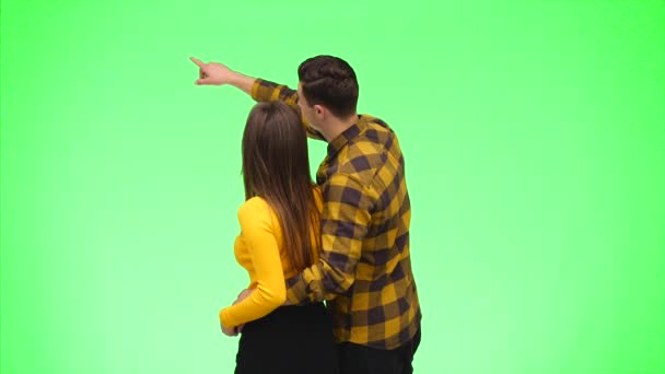 Vue arrière du jeune couple pointant les doigts ensemble. Ferme là. Espace de copie. 4K . — Video