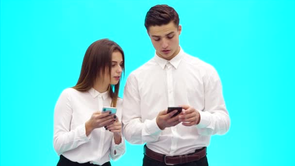 Två affärsmän konsulterar och står på azurblå bakgrund. Närbild. Uppfattat utrymme. 4k. — Stockvideo