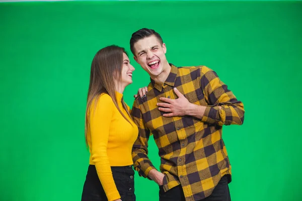 Portrait of girl whispering into mans ear, telling him something really funny because he is smiling desparately. — Stockfoto