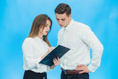 Concentrated business people working with papers standing over blue background.
