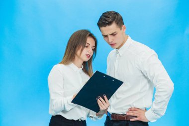 Concentrated business people working with papers standing over blue background.