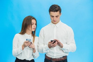 Business people using smartphones, completing some work tasks against blue background.