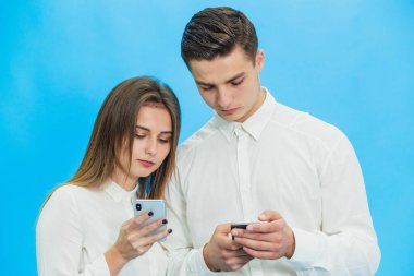 Business people using smartphones, completing some work tasks against blue background.