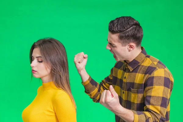 Homem extremamente irritado com a namorada, gritando com ela, warnig com punho, ela fica para trás para ela, não prestando atenção . — Fotografia de Stock