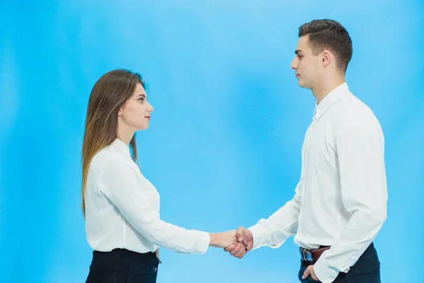 Портрет деловых партнеров, заключающих сделку в офисе, пожимающих руки на синем фоне . — стоковое фото