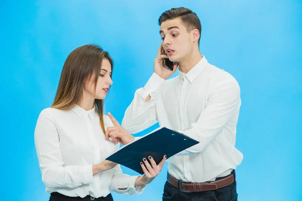 Portret przystojnego biznesmena rozmawiającego przez telefon i jego sekretarka robiącego notatki na niebieskim tle. — Zdjęcie stockowe