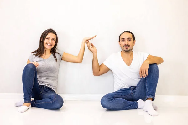 Sorrindo jovem casal segurando palma aberta com espaço de cópia para texto ou produto isolado em fundo branco . — Fotografia de Stock