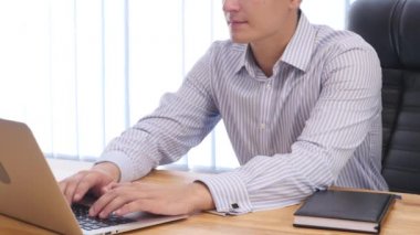 Businessmans hands type at desktop keyboard in workspace. Close up. Copy space. Crop. 4K.