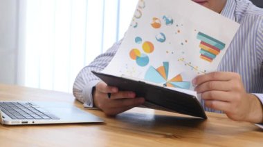 Close up. Businessmans hands looking throught the clipboard files. Searching and reading text. Man puts his head down, feeling failure. Copy psace. 4K.