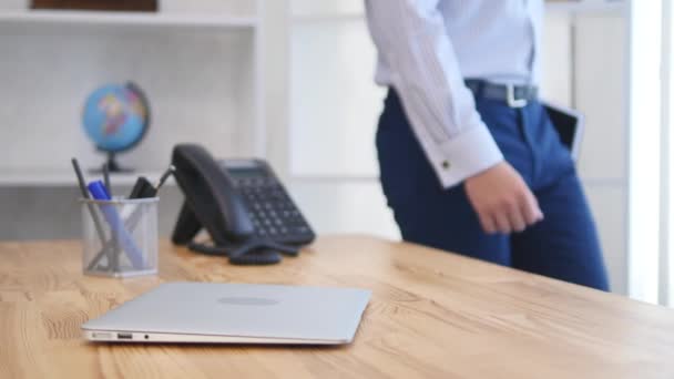 El hombre de negocios viene con un cuaderno negro en sus manos, y comienza a trabajar. De cerca. Copiar espacio. 4K . — Vídeos de Stock