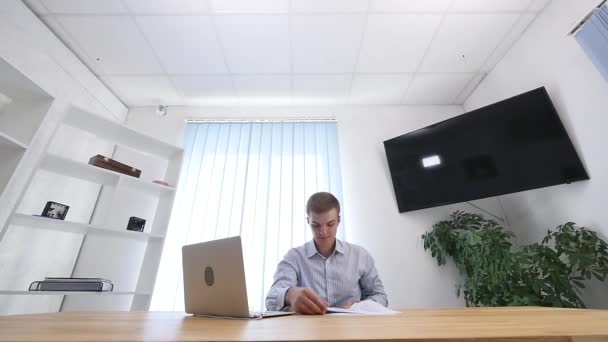 벌레 눈. 젊은 사업가 가 사무실에서 서류를 읽고 있습니다. 그는 그것들을 던져 버리고 사무실 의자에 누인다. 닫아. 복사 공간. 4k. — 비디오