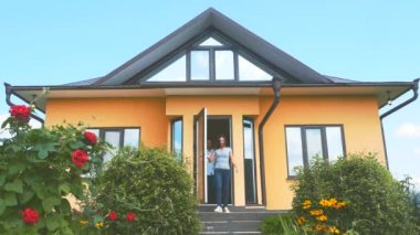 Young happy couple is getting ready to go on holiday vacation. They are running from the house to unpredictible trip. Copy space. 4K.