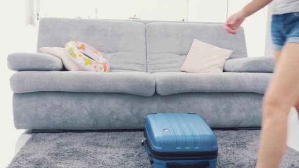 La mamma è pronta a fare le valigie e a rimanere bloccata in un'enorme valigia blu. Mi sto preparando per il viaggio. 4K . — Video Stock