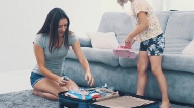 Annem kocaman mavi bir bavul hazırlıyor. Küçük kız ona çobanlık yapıyor. Seyahate hazırlanıyorum. 4k.