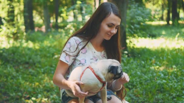 Young woman feeding her small pug dog with sweet ice-cream. Close up. Copy space. 4K. — Stock Video