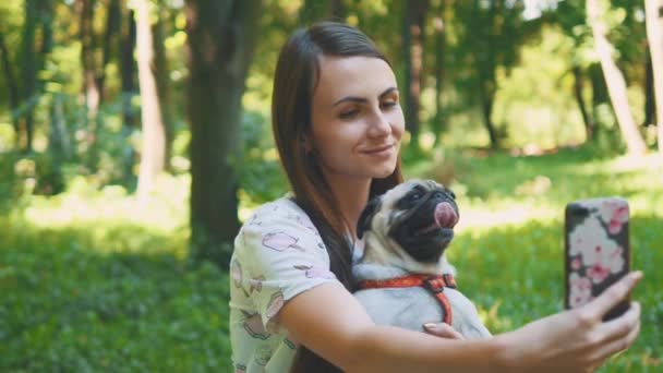 Mulher está tomando selfie pelo telefone celular com seu cachorro. Fecha. Espaço para cópia. 4K . — Vídeo de Stock