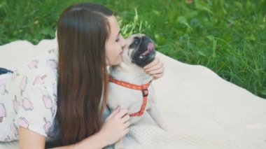 Smiling lady is taking free time with her dog. Woman relaxing in the nature with her little pug dog. Crop. Close up. Copy space. 4K.