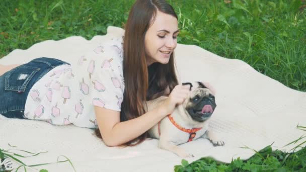 Smiling lady is taking free time with her dog. Woman relaxing in the nature with her little pug dog. Crop. Close up. Copy space. 4K. — Wideo stockowe