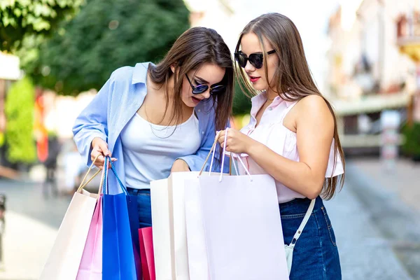 Beautiful shopping women with bags gossiping about what theyve bought. — Stockfoto