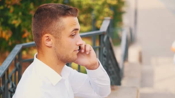 Successful, confident business man is on the phone, isolated, street background. Close up. Copy space. 4K. — Αρχείο Βίντεο