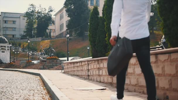 Handsome young business man in a white shirt is walking on streets. Close up. Slowmo. Slow motion. Copy space. 4K. — Wideo stockowe
