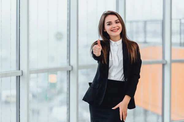 Pretty office employee showing thumb up isolated near window. — Stock Photo, Image