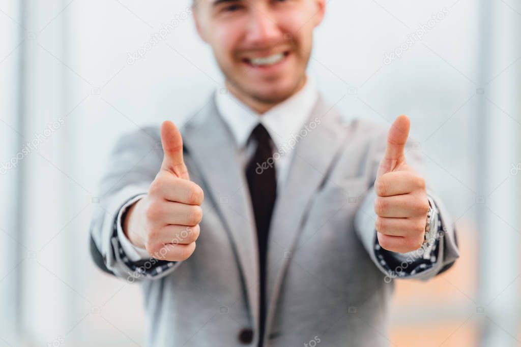 Cropped photo of satisfied businessman showing thumbs up.Focus on the gesture on the forefront.