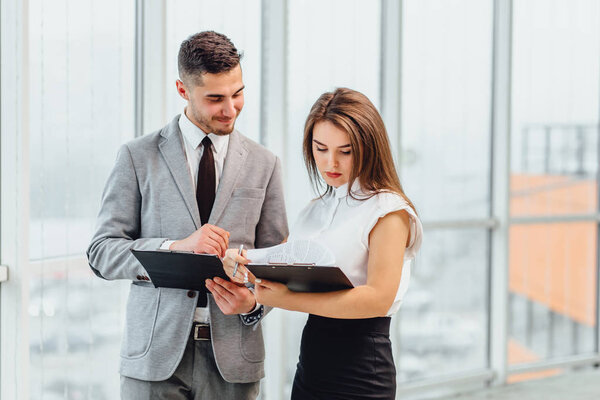 Успешный мужчина и женщина, составляющие бизнес-план, сравнивающие друг друга исследования
.