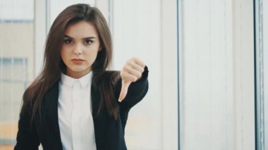 Business woman shows disapproval for camera with her thumb finger down, isolated on white panoramic background. Close up. Copy space. 4K.