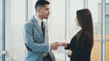 Adam panoramik pencereden dışarı bakıyor. Panoramik arka planda ofisteki iki iş adamını tanıyorum. Kapatın. Uzayı kopyala 4k.