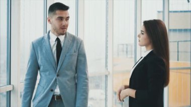 Adam panoramik pencereden dışarı bakıyor. Panoramik arka planda ofisteki iki iş adamını tanıyorum. Kapatın. Uzayı kopyala 4k.